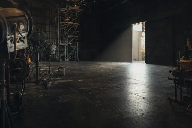 L'interno del Teatro 5 di Cinecittà, vuoto, con il traliccio di servizio e un fascio di luce dal portone